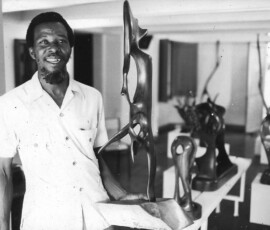 artist standing by the art work